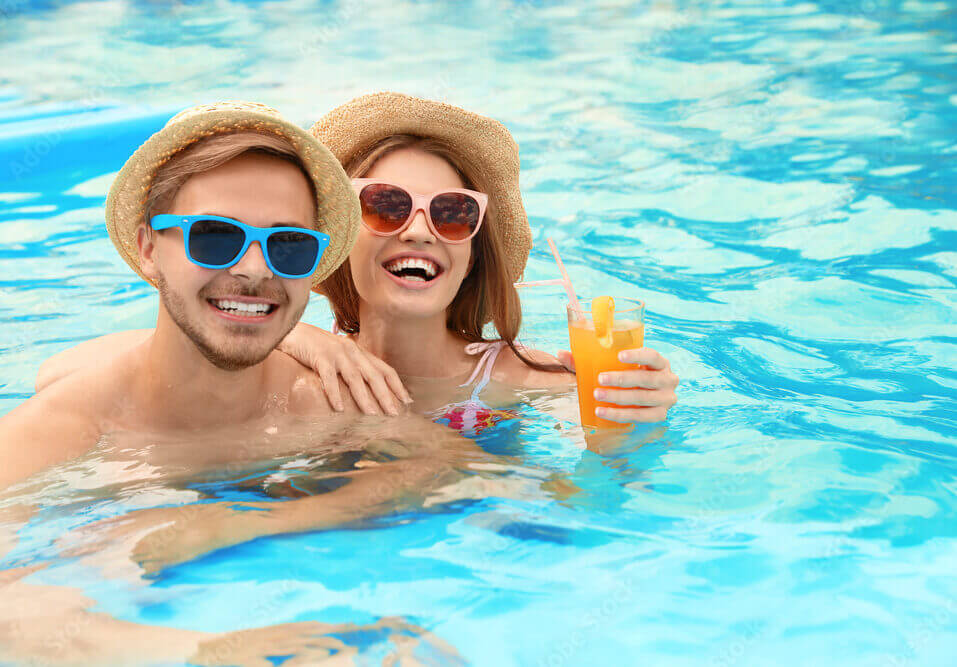 Young couple in pool on sunny day